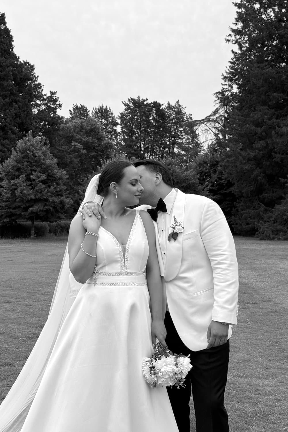 Los novios se abrazan riendo en el jardín después de la ceremonia